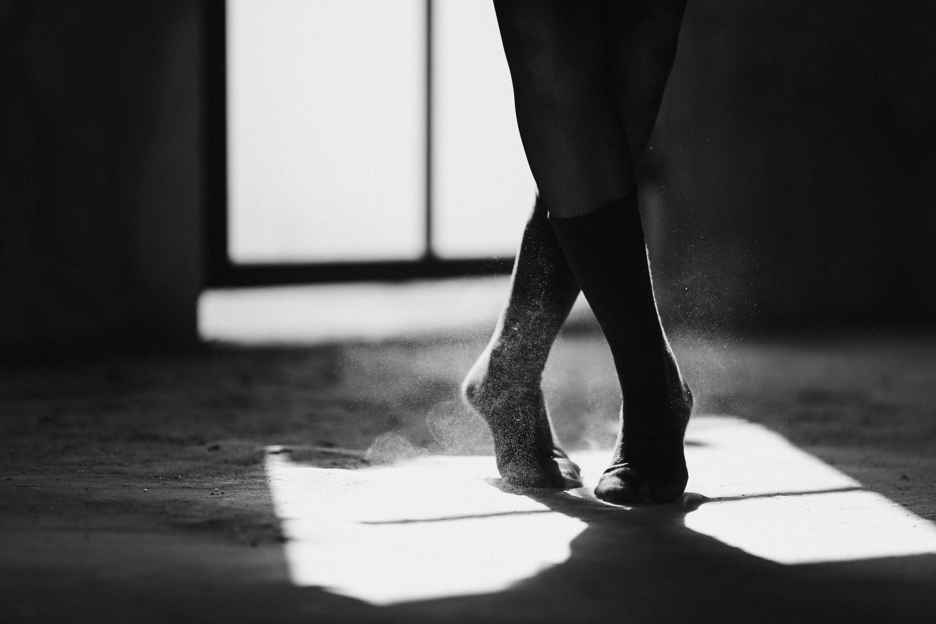 crop ballerina silhouette dancing on floor with shadow